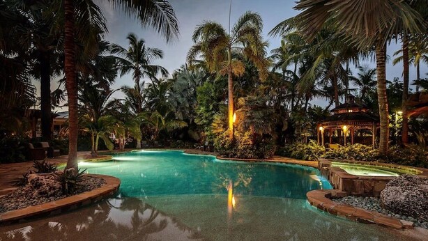 A swimming pool surrounded by palm trees and a gazebo. - New Caribbean home.  Resort access to pool (Islamorada)