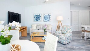 Una sala de estar moderna con un sofá, sillones, una mesa de centro y obras de arte en las paredes.