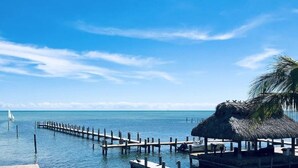 A pier extending into calm waters with a thatched-roof structure at the end. - Luxurious Caribbean 2 Bedroom 2 Bath Home (Islamorada)
