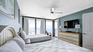 A hotel room with two beds, a ceiling fan, a TV, and a view of the ocean. - Penthouse with an Amazing views! (Ocean City)