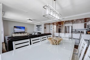 A modern kitchen with white cabinets, stainless steel appliances, and a central island.