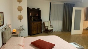 A bedroom with a bed, a wooden dresser, a chair, and a door. - SUMMER WITH ME😁 (Bari)