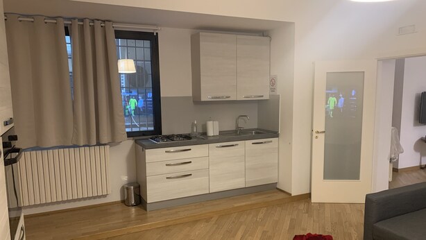 A modern kitchen with white cabinets, a gas stove, and a window with curtains. - SUMMER WITH ME😁 (Bari)