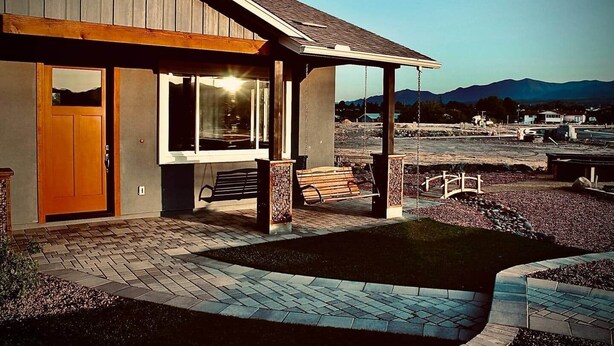 A building with a covered porch, a bench, and a view of mountains. - Kickin' It on Kindra! Modern 3 Bedroom New Build! (Cottonwood)