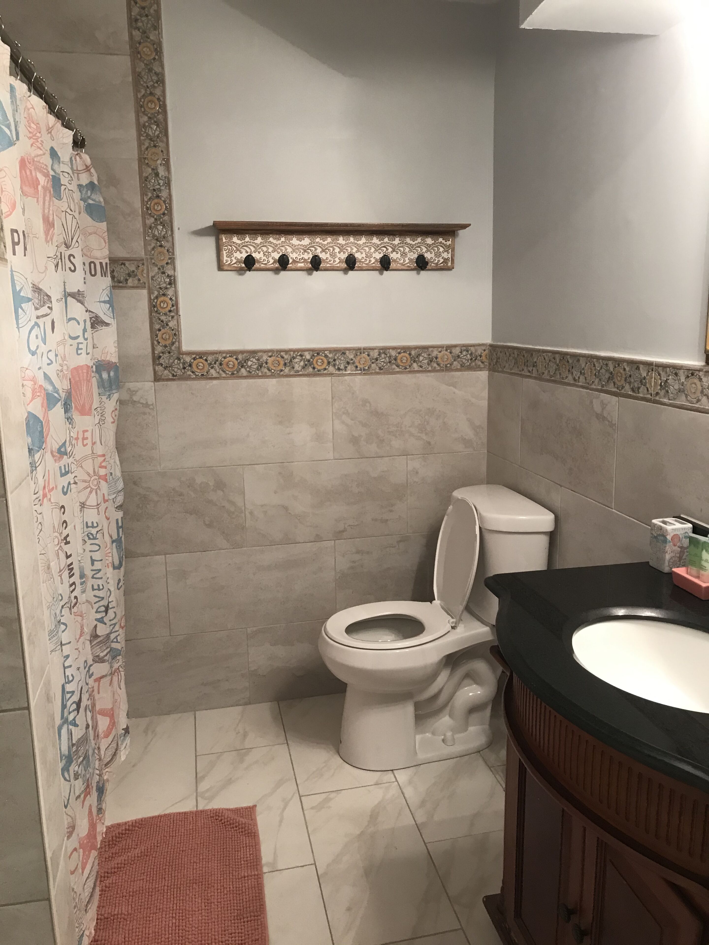 A bathroom with a toilet, sink, and shower curtain.