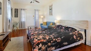 A bedroom with a bed, a ceiling fan, a desk, a chair, and a sofa. - Fab Studio | Walk to Food and Music | Pet Friendly (New Orleans)