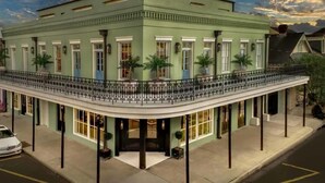 A historic building with a curved balcony, large windows, and a classic architectural style.