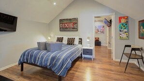 A bedroom with a bed, nightstands, a chair, and a ceiling fan. - Charming Central 2BR | Courtyard | Pet Friendly (New Orleans)