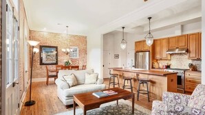 A modern kitchen with wooden cabinets, a central island, and bar stools.
