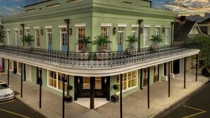 A historic building with a curved balcony, large windows, and a classic architectural style.