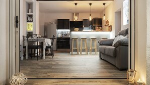 A modern kitchen with a central island, wooden stools, and pendant lighting.