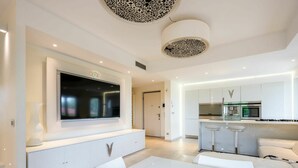 Una cocina moderna con armarios blancos, horno empotrado y microondas.