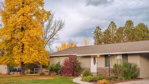 A single-story building with a front lawn, a driveway, and a street view. - Highland Hideaway, Room for everyone, central to everything (Highland)