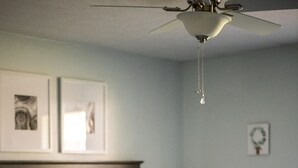 A bedroom with a bed, pillows, a bedside lamp, and a ceiling fan. - Highland Hideaway, Room for everyone, central to everything (Highland)