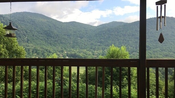 A wooden deck with a view of a mountainous landscape.