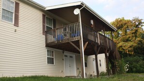 A two-story house with a balcony and a covered porch.