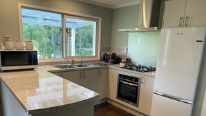 Eine moderne Küche mit Backofen, Kühlschrank und Gaskochfeld.