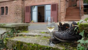 Un paio di stivali e un bicchiere da vino su un gradino in pietra, con un edificio sullo sfondo.