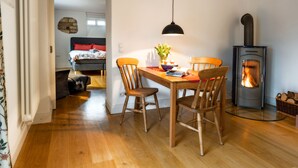 Un'accogliente zona pranzo con tavolo, sedie e stufa a legna.