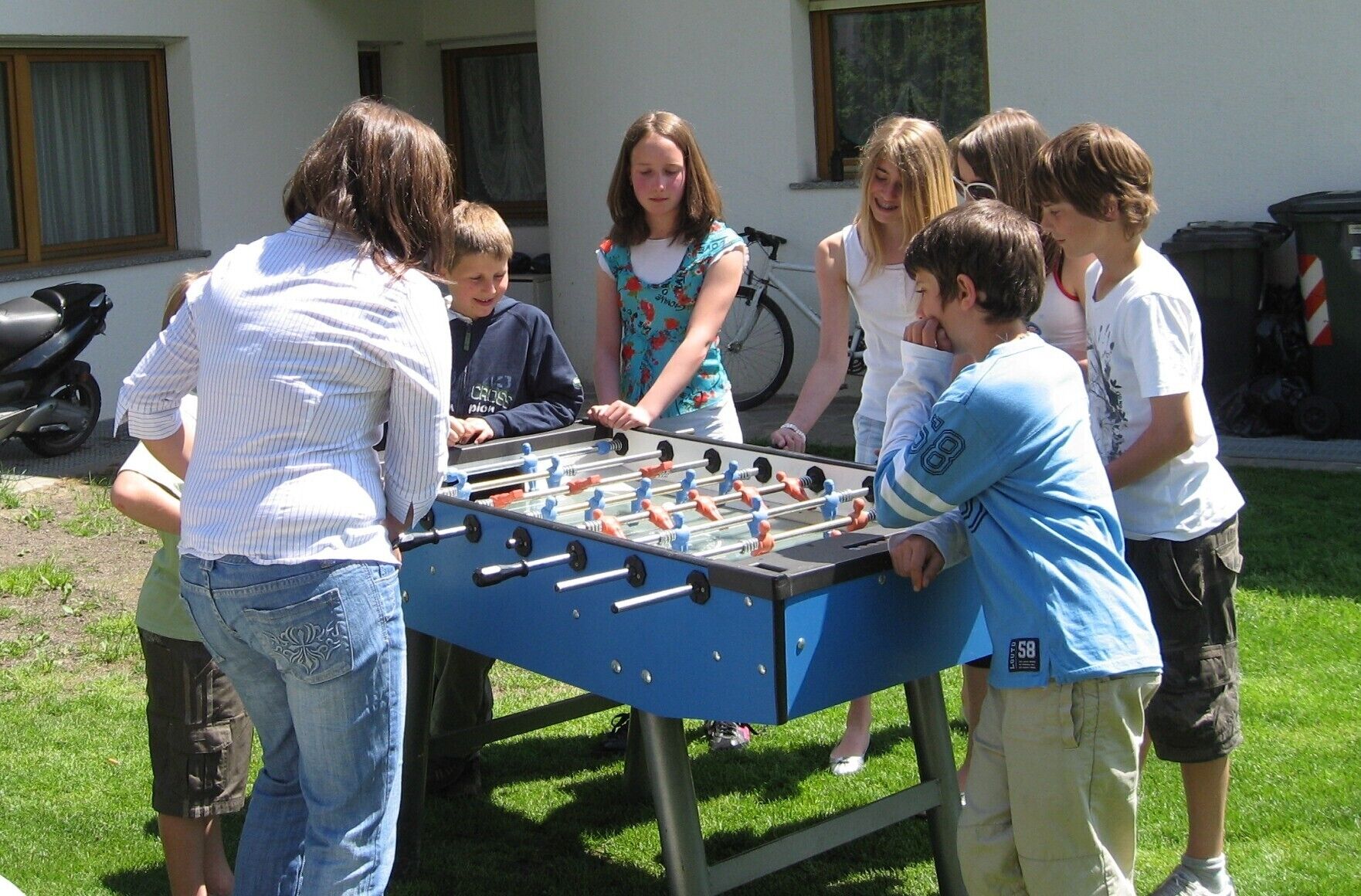A group of people playing foosball outdoors.