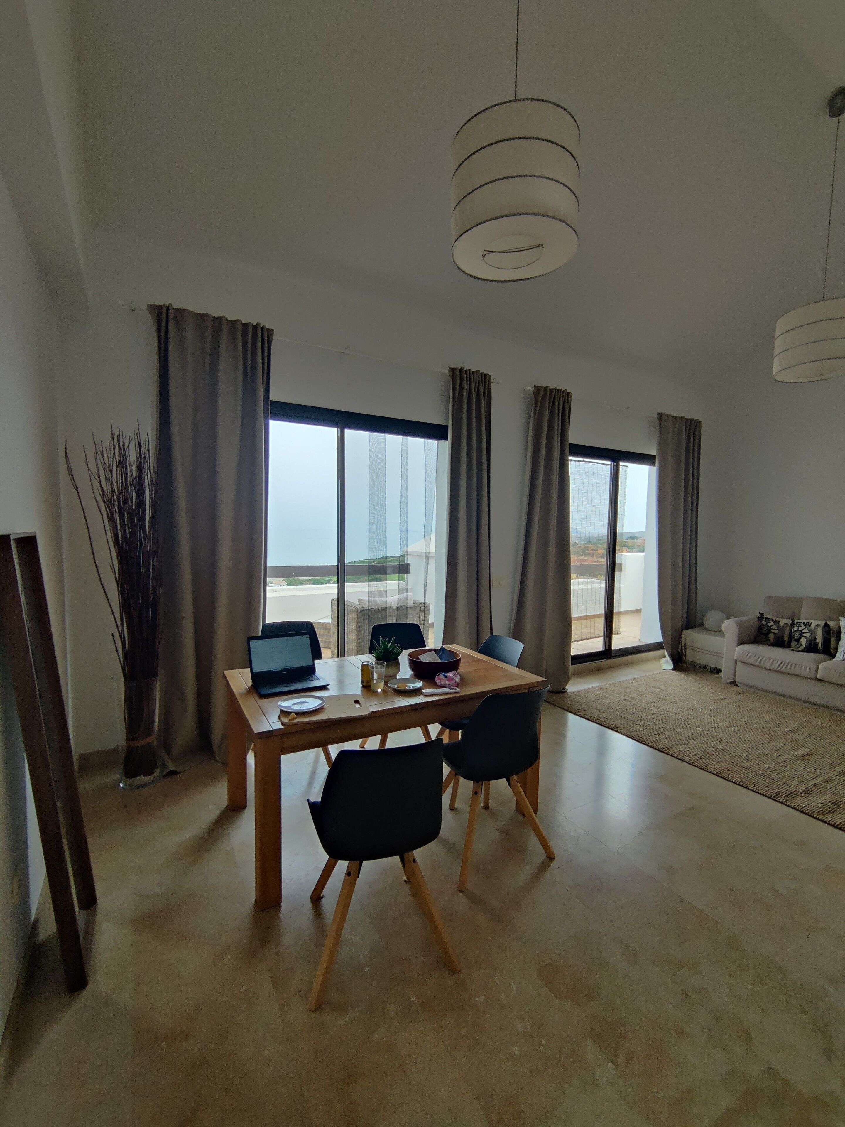 Una sala moderna con comedor, ventanas grandes y vistas al exterior.
