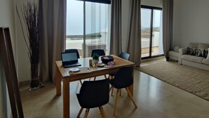 Una sala moderna con comedor, ventanas grandes y vistas al exterior.