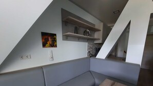A modern kitchen with a built-in bench, a wooden table, and a wall-mounted shelf with kitchenware. - Room 1 - Lakeland oasis Reppist (Senftenberg)