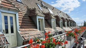 A row of terraced houses with dormer windows and a balcony with red flowers. - Room 1 - Lakeland oasis Reppist (Senftenberg)