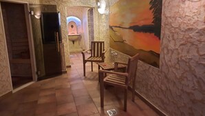 A hallway with a stone wall, a painting of a sunset, and a wooden chair. - Room 1 - Lakeland oasis Reppist (Senftenberg)