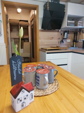 A kitchen with wooden cabinets, a countertop, and various kitchen utensils.