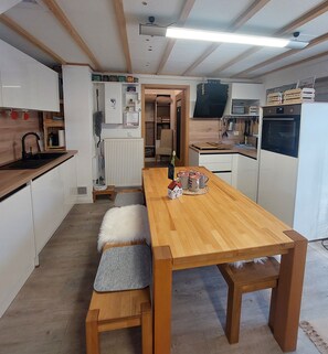 A compact kitchen with wooden countertops, a central island, and a built-in oven.