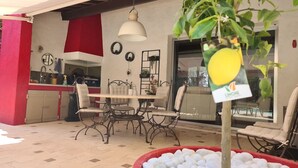 Un patio con mesa, sillas y una planta en maceta.