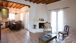 Un espacio habitable amplio con una mesa de comedor, sillas, chimenea y sofá.