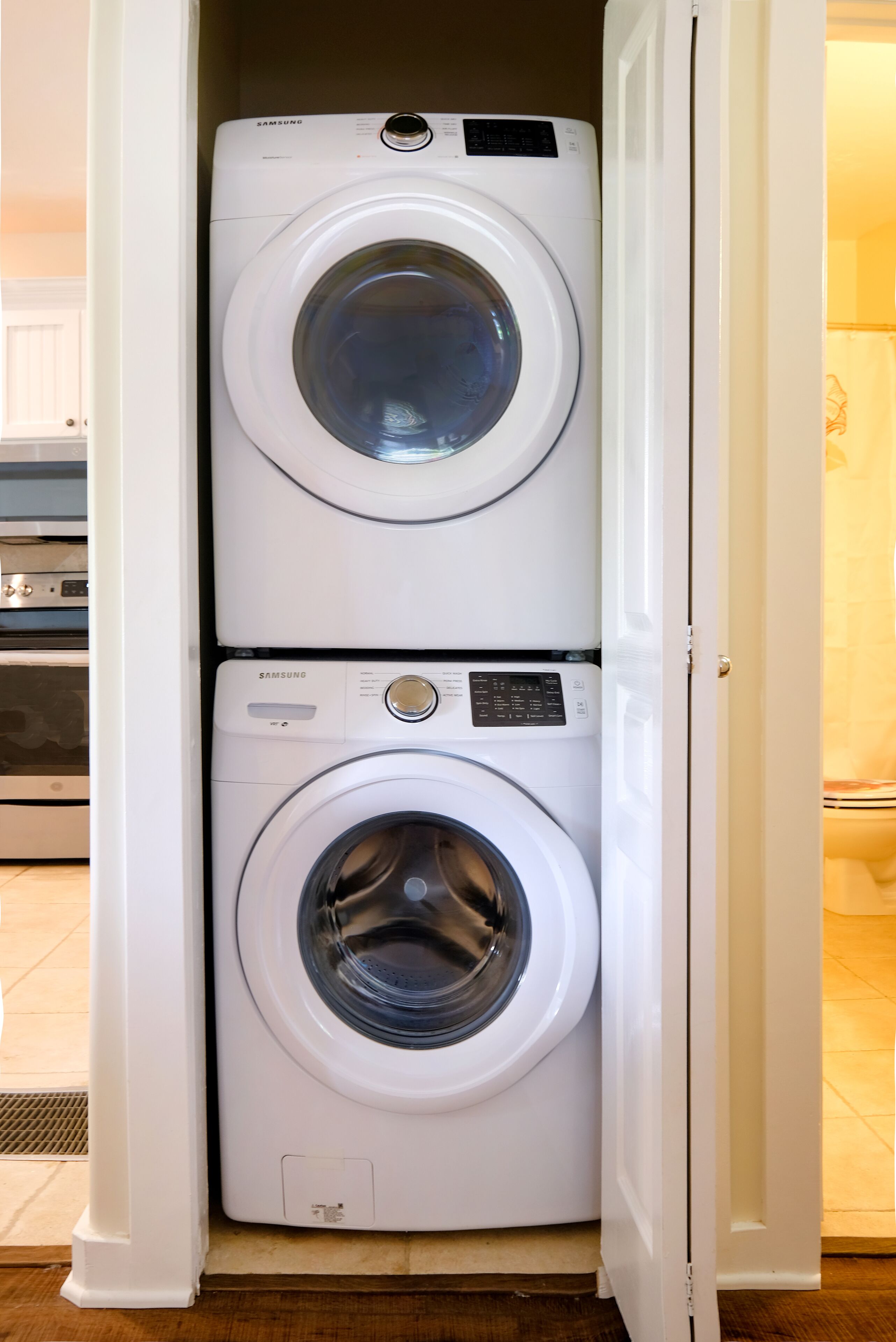 A laundry room with two stacked Samsung washing machines.
