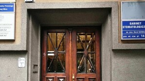 A wooden double door with glass panels and decorative elements, set in a stone building facade. - Designer Apartment 110m² w/ King Beds, Balcony, Smart TV + Equipped Kitchen (Kraków)