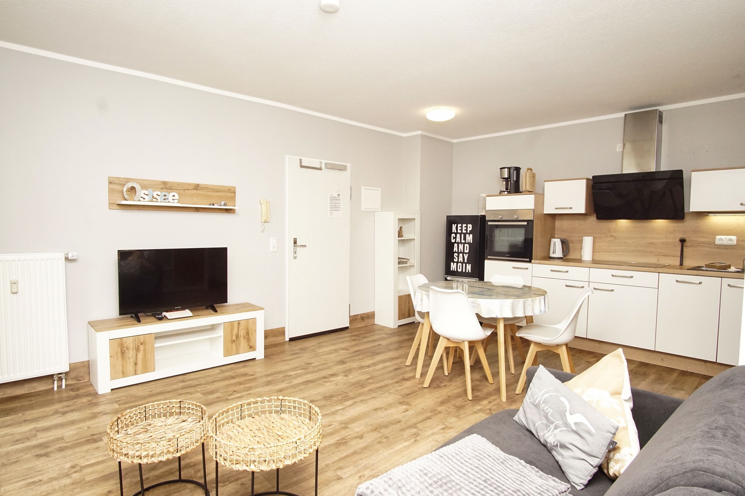A modern living room with a TV, sofa, and dining area.