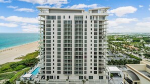 Un hôtel de grande hauteur doté de nombreux balcons, d’une piscine et offrant une vue sur la plage.