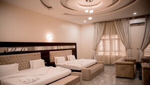 Una habitación de hotel con dos camas, un sofá y una pequeña mesa.