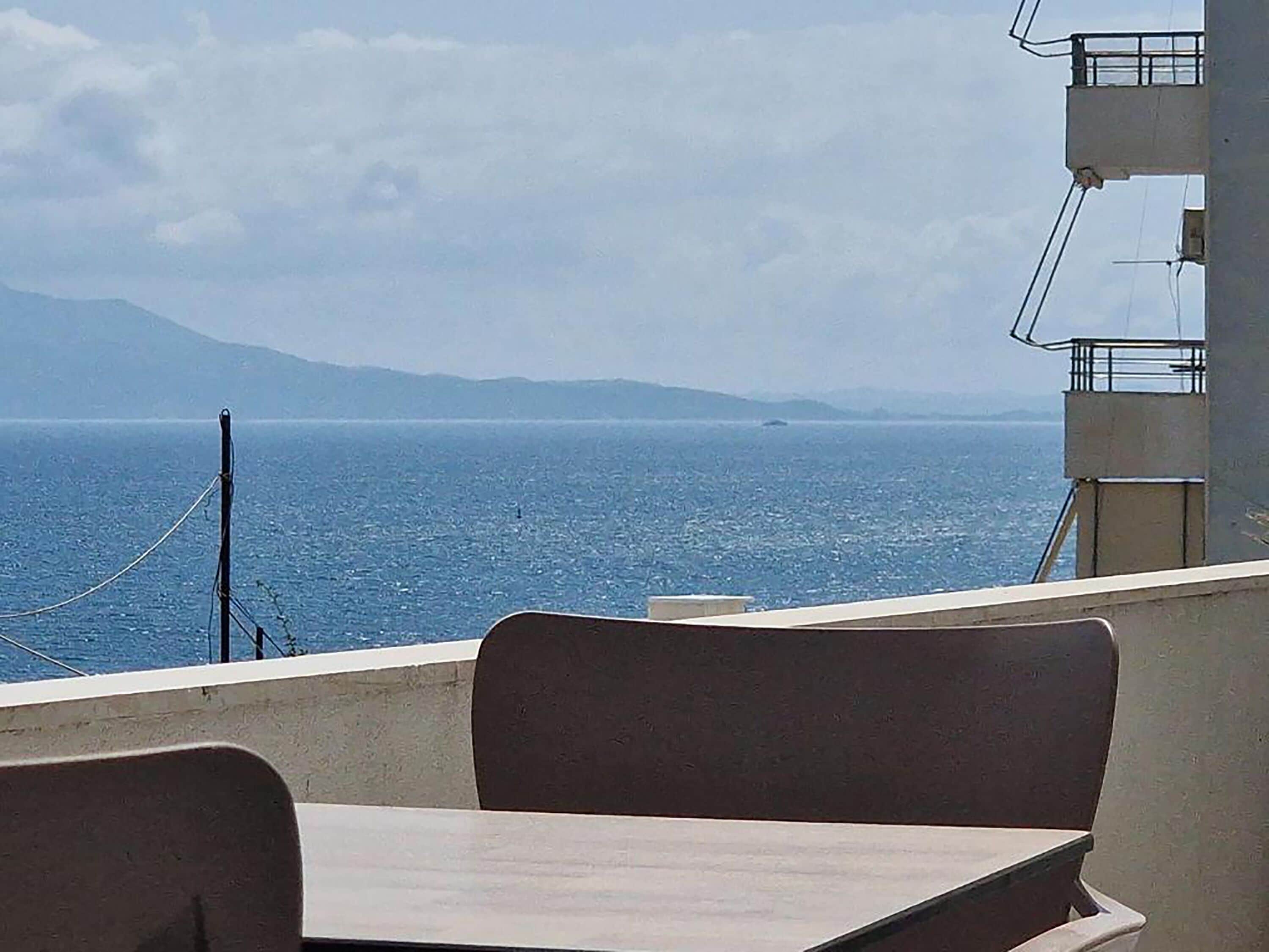 Un balcon avec vue sur la mer et les montagnes lointaines.