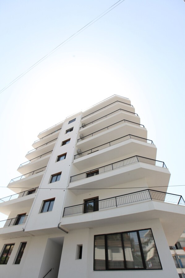 A multi-story building with balconies and large windows.