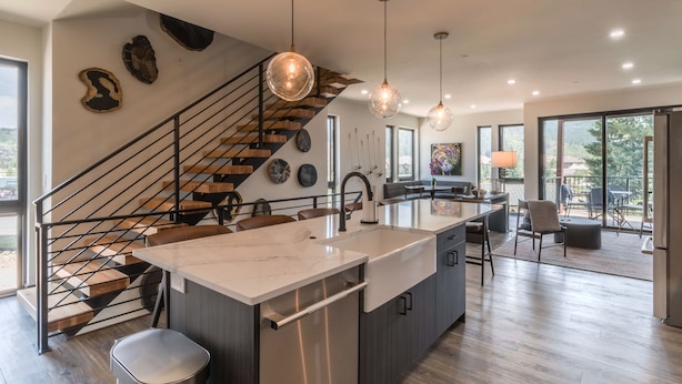 A modern kitchen with a central island, stainless steel appliances, and pendant lighting.