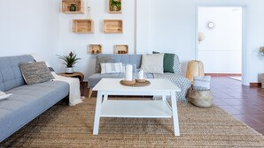 A modern living room with a grey sofa, a white coffee table, and wooden crates on the wall.