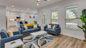 A modern living room with a sofa set, a coffee table, and a ceiling fan. - Modern and Comfortable Home Close to Downtown (Dallas)