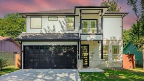A modern two-story house with a garage, a balcony, and a stone facade. - Modern and Comfortable Home Close to Downtown (Dallas)