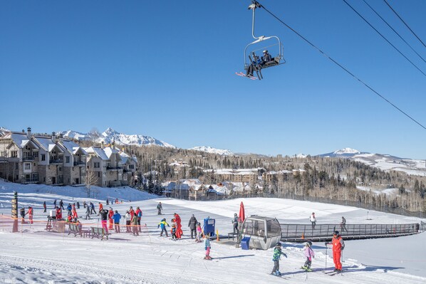 A ski resort with a chairlift, snow-covered mountains, and lodge buildings. - ASPENS AT COURCHEVAL- Unbeatable Ski Access, Views & Hot Tub (Mountain Village)