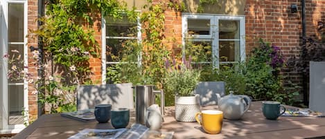 Enjoy a meal al fresco in this serene outdoor seating area surrounded by lush greenery.