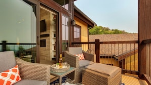 A balcony with wicker furniture, a glass door, and a view of a building and greenery. - Experience comfort in Park City Fairway Springs 4221, a 3BR townhome near Canyons Village. (Park City)