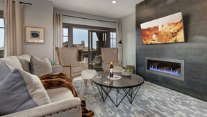 A modern living room with a fireplace, a large TV, and a cozy seating area. - Experience comfort in Park City Fairway Springs 4221, a 3BR townhome near Canyons Village. (Park City)