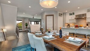 A modern kitchen with white cabinets, a wooden dining table set for four, and a view of the outdoors. - Experience comfort in Park City Fairway Springs 4221, a 3BR townhome near Canyons Village. (Park City)