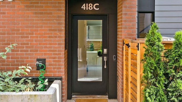 Entrada de un edificio moderno con una puerta negra que indica "418C".